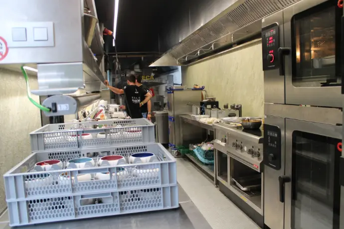 Koks in actie in trailer Versu porselein, met op de achtergrond Vomeca koelcel
